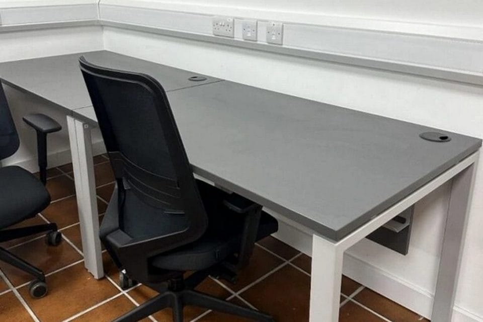 Desk workspace at Irish Town Business Centre, Gibraltar Row of grey desks with office chairs and power sockets at Irish Town Business Centre in Gibraltar